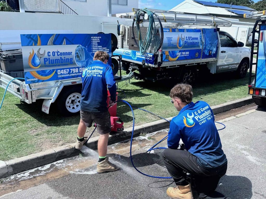 Plumbers fixing a blocked drain